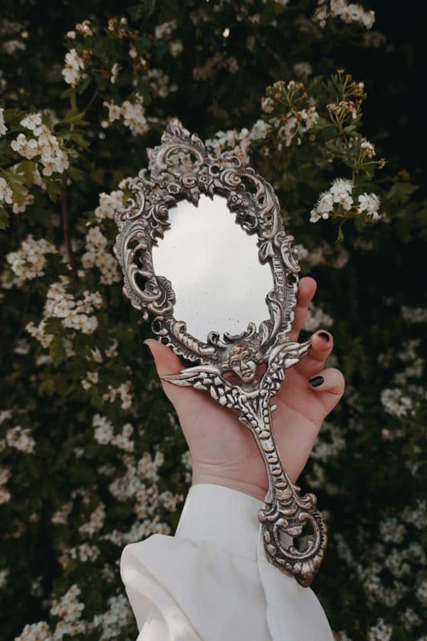 mirror-scrying image of a mirror being held in a hand from unsplash